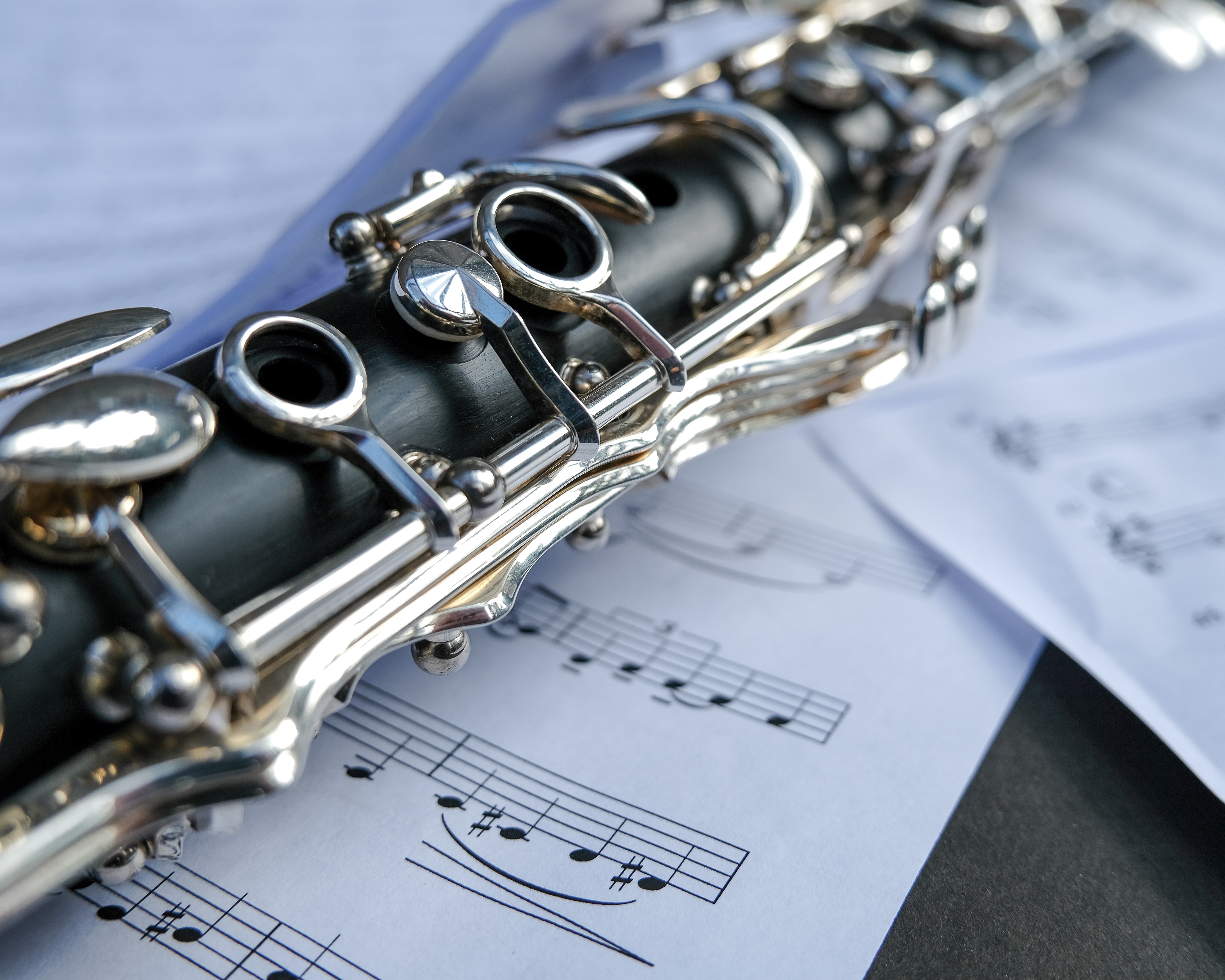 closeup of clarinet on top of sheet music